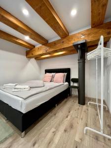 1 dormitorio con cama y techo de madera en The Lovely Loft, en Liubliana