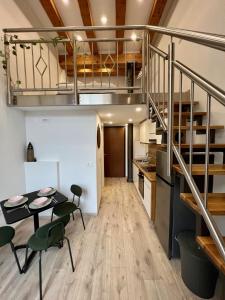 Habitación con mesa, sillas y escalera. en The Lovely Loft, en Liubliana