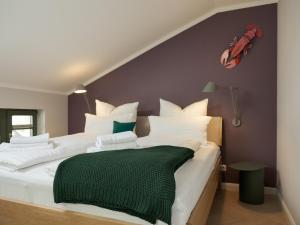 a bedroom with a large bed with a green blanket on it at OSTKÜSTE - Villa Steigel Design Apartments in Ahlbeck