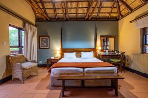 a bedroom with a bed and a desk in a room at Pestana Kruger Lodge in Malelane
