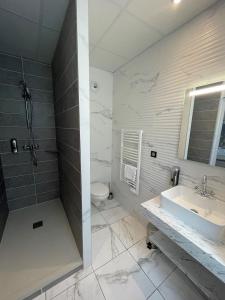 La salle de bains est pourvue d'un lavabo et de toilettes. dans l'établissement Domaine Clairfontaine Noyarey - Suites Junior, à Noyarey