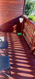 a wooden deck with two chairs and a butterfly on it at Studio Adela in Poiana Brasov