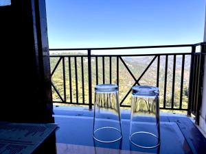 HANU VATIKA The FAMILY CHOICE في شيملا: وجود مزهريتين زجاجيتين على طاولة في الشرفة