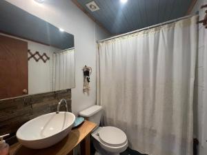 uma casa de banho com um lavatório branco e um WC. em Hamilton's Place Bed and Breakfast em La Ensenada mais 22 fotografias