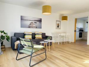 sala de estar con sofá, mesa y sillas en aday - Central Terrace Apartment in Hjorring, en Hjørring