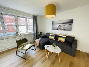 a living room with a couch and a table at aday - Central Terrace Apartment in Hjorring in Hjørring