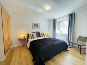 a bedroom with a bed with a black comforter at aday - Central Terrace Apartment in Hjorring in Hjørring
