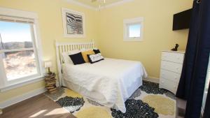 a bedroom with a white bed and a window at Semi-Oceanfront, Wild Horses, Hot Tub, Ocean Views! 4x2000, Sandfiddler Inn in Knotts Island
