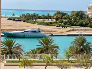 Marina Deluxe 2, family only في King Abdullah Economic City: قارب متوقف على الماء بجوار شاطئ