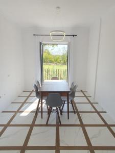 a dining room with a table and chairs and a window at Nerium Garden Inn Tirana Airport in Rinas