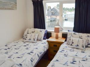 two twin beds in a room with a window at Nightingale in Wroxham