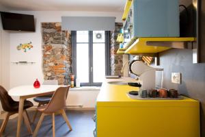 uma cozinha com um balcão amarelo e uma mesa em Baby Art Apartment em Arona