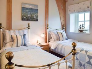 a bedroom with two beds and a window at Soar Cottage in Dihewid