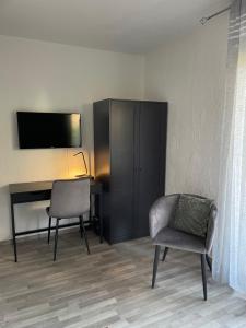 een kamer met een bureau, een stoel en een televisie bij Studio Ma Préférence in Horbourg