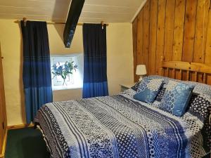 um quarto com uma cama com lençóis azuis e brancos em Hendy em Waenfawr
