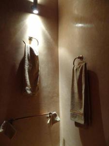 a bathroom with a mirror and towels on a wall at Ryad Nour Al Janoub in Marrakech