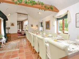 a dining room with a long table and white chairs at Doves Barn in Needham Market