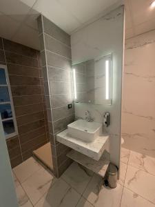 La salle de bains est pourvue d'un lavabo et d'un miroir. dans l'établissement Domaine Clairfontaine Noyarey - Suites Junior, à Noyarey