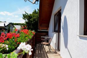 balcón con mesa, sillas y flores en Apartment Corak, en Grabovac