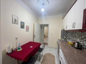 une cuisine avec une table et un chiffon rouge dans l'établissement 2 bedroom family apartment in the city center, à Antalya