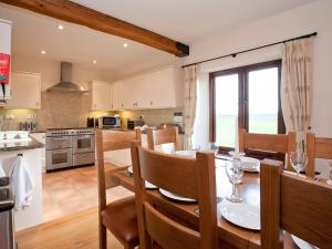 a kitchen and dining room with a table and chairs at Kingfisher Barn in Sculthorpe