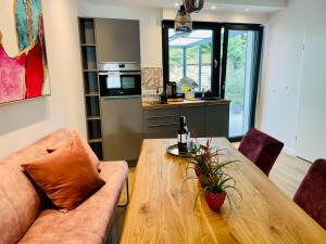 ein Wohnzimmer mit einem Holztisch und einer Küche in der Unterkunft Der Vitihof Pastoren Suite in Osnabrück