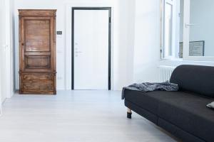 a living room with a black couch and a door at La Dimora Della Torretta in Cantù