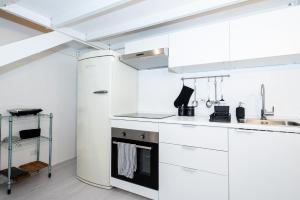 a white kitchen with a stove and a sink at La Dimora Della Torretta in Cantù