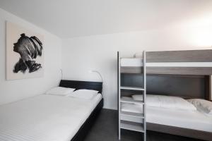 a room with two bunk beds and a ladder at Studio VICTORIA Interlaken in Interlaken