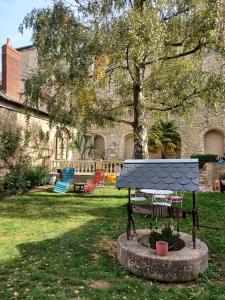 a park with a table and chairs in a yard at Au puits de l'abbaye in Bourges