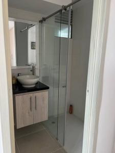 y baño con ducha acristalada y lavamanos. en Apartamento completo 3 habitaciones, en Neiva