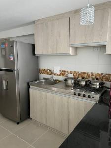 een keuken met een fornuis en een roestvrijstalen koelkast bij Apartamento completo 3 habitaciones in Neiva