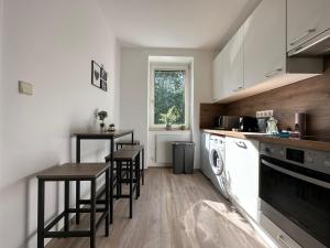 a kitchen with a table and two stools in it at FeelHome-GolfClub-Balkon-4 Gäste-WiFi-Smart TV in Ebreichsdorf