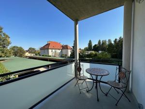 a patio with a table and chairs on a balcony at FeelHome-GolfClub-Balkon-4 Gäste-WiFi-Smart TV in Ebreichsdorf