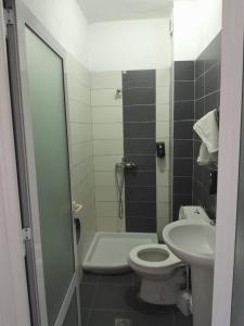 y baño con aseo y lavamanos. en Hotel Unik, en Pogradec