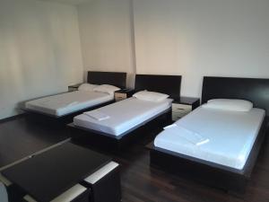 three beds sitting in a room with at Hotel Unik in Pogradec