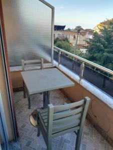 einen Tisch und Stühle auf einem Balkon mit Fenster in der Unterkunft Hotel Unik in Pogradec