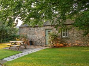 a picnic table in front of a stone house at The Coach House in Mathry