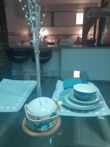 una mesa de cristal con platos y un jarrón encima en CASA CALIDA, en Huancayo