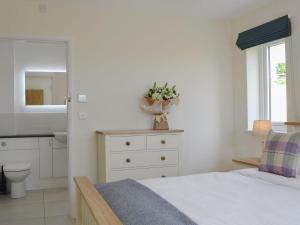 a bedroom with a bed and a sink and a mirror at Orchard Cottage in Morville