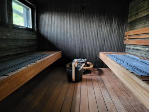 a small room with two benches and a pot on the floor at Tuorilan tupa in Jämsä