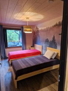 twee bedden in een kamer met een schilderij aan de muur bij Tuorilan tupa in Jämsä