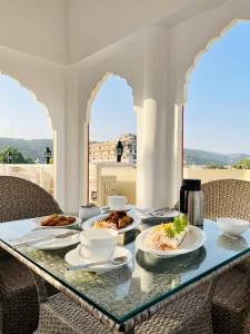 una mesa de cristal con platos de comida. en Hotel Amayra, en Jaipur