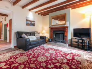 a living room with a couch and a fireplace at Half Penny Cottage in Docking