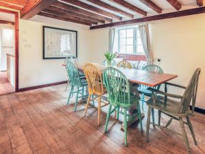 comedor con mesa de madera y sillas en Half Penny Cottage, en Docking