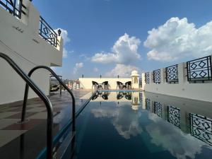 una piscina de agua en el patio de un edificio en Hotel Amayra, en Jaipur