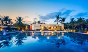 um resort com piscina à noite em Grandvrio Ocean Resort Danang em Hoi An