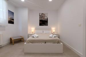 ein weißes Schlafzimmer mit einem Bett mit zwei Lampen in der Unterkunft Unamuno Old Town 1 Free Parking in Bilbao