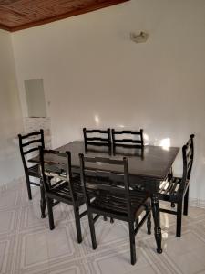 een eettafel met 3 stoelen en een tafel en stoelen bij Topsta Apartment in Kisii