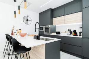a kitchen with black and white cabinets and a kitchen island at Moderna Casa VillaCristal in Daya Vieja